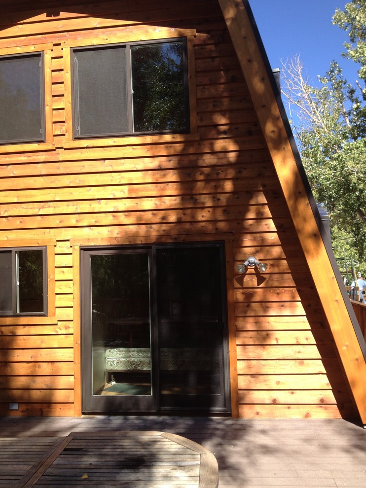 Example of a large mountain style brown two-story wood house exterior design with a metal roof