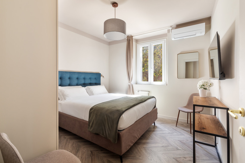 Foto de dormitorio principal y televisión bohemio con paredes beige, suelo laminado, suelo beige y bandeja