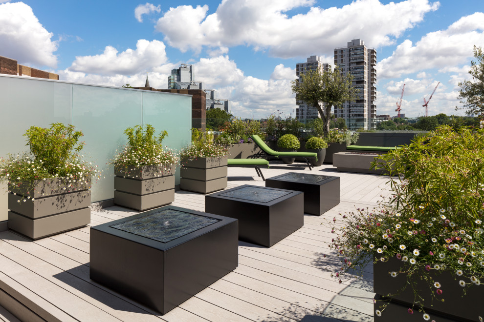 Mid-sized contemporary rooftop deck in London with a water feature and no cover.