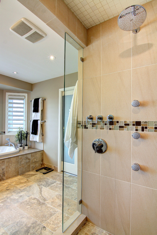 Design ideas for a large transitional master bathroom in Calgary with an undermount sink, recessed-panel cabinets, dark wood cabinets, solid surface benchtops, an alcove shower, a one-piece toilet, brown tile, porcelain tile, beige walls, a drop-in tub and porcelain floors.