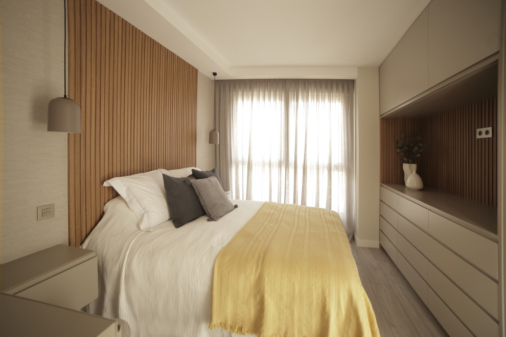 Diseño de dormitorio principal y gris y negro moderno de tamaño medio con paredes beige, suelo de madera clara, suelo gris y papel pintado