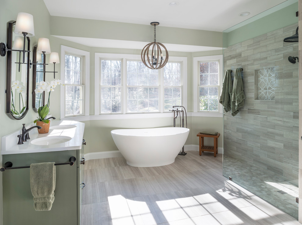Transitional bathroom in DC Metro with green cabinets, a freestanding tub, an open shower, beige tile, marble, green walls, porcelain floors, an undermount sink, engineered quartz benchtops, beige floor, an open shower and white benchtops.