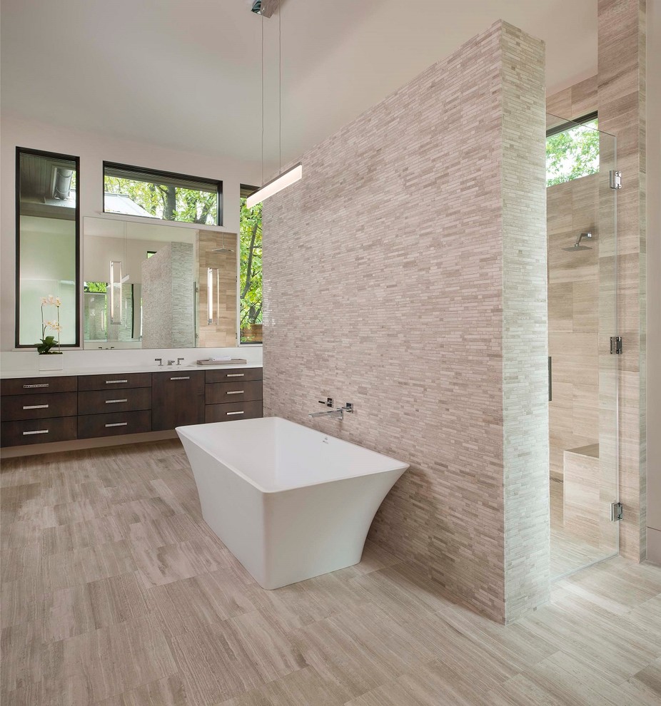 Photo of a mid-sized contemporary master wet room bathroom in Dallas with dark wood cabinets, a freestanding tub, an undermount sink, engineered quartz benchtops, flat-panel cabinets, a one-piece toilet, stone tile, beige walls, porcelain floors, beige floor and a hinged shower door.