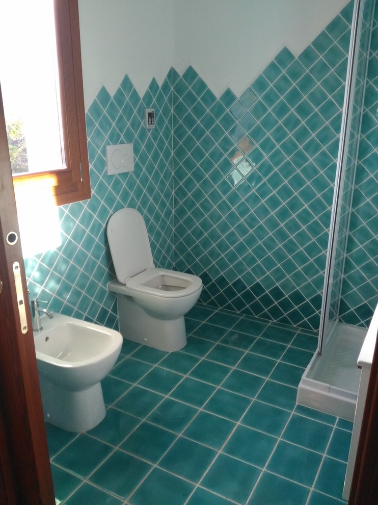 Photo of a beach style powder room in Other with louvered cabinets, a one-piece toilet, green tile, ceramic tile, white walls, ceramic floors, an integrated sink, green floor and white cabinets.
