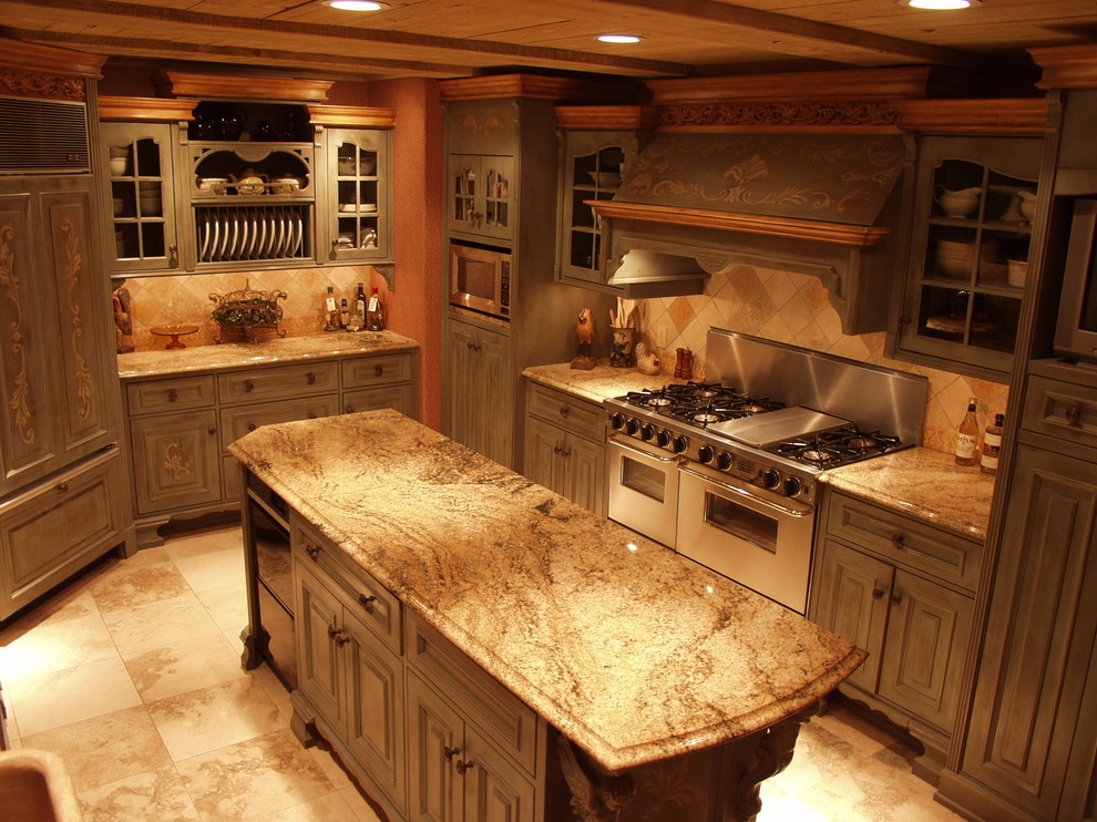 Large mountain style l-shaped medium tone wood floor and brown floor open concept kitchen photo with granite countertops, brown backsplash, stone tile backsplash, stainless steel appliances, an island, a farmhouse sink and green cabinets