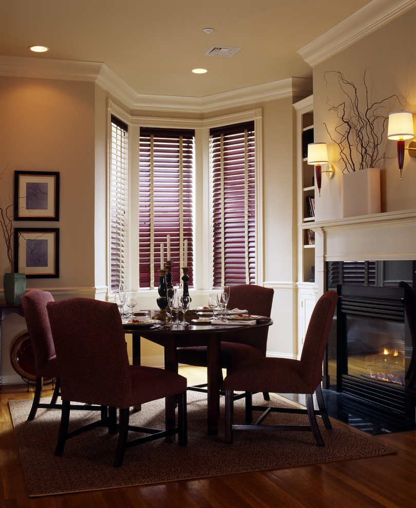 Photo of a traditional dining room in San Francisco with beige walls, dark hardwood floors and a wood stove.