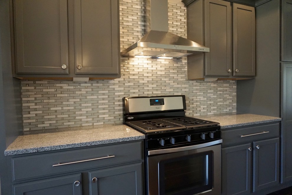 Kitchen - mid-sized modern kitchen idea with shaker cabinets, gray cabinets, granite countertops, gray backsplash, glass tile backsplash and stainless steel appliances