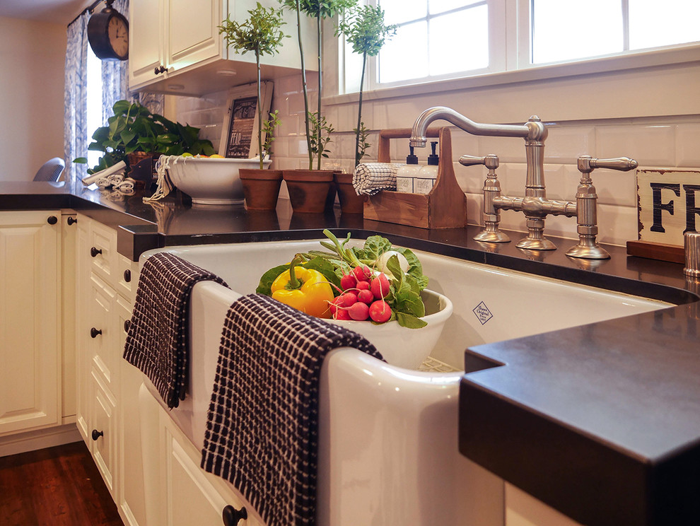 Design ideas for a country galley kitchen in San Diego with a farmhouse sink, white cabinets, onyx benchtops, white splashback, subway tile splashback, stainless steel appliances and medium hardwood floors.