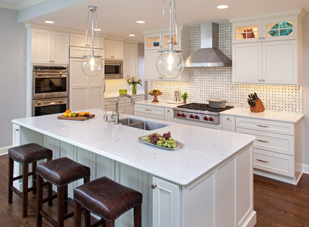 Example of a large transitional galley dark wood floor open concept kitchen design in Minneapolis with an undermount sink, recessed-panel cabinets, white cabinets, quartzite countertops, white backsplash, mosaic tile backsplash, stainless steel appliances and an island