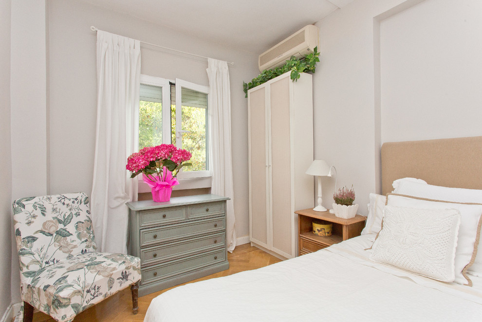 Modelo de dormitorio principal romántico de tamaño medio sin chimenea con paredes blancas y suelo de madera en tonos medios