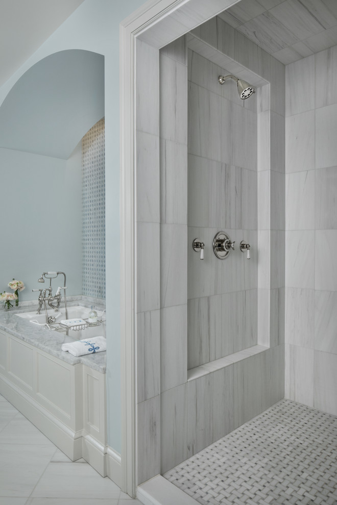 Design ideas for an expansive traditional master bathroom in Detroit with furniture-like cabinets, white cabinets, a drop-in tub, an alcove shower, a one-piece toilet, blue tile, glass tile, white walls, travertine floors, an undermount sink, marble benchtops, white floor, a hinged shower door and white benchtops.