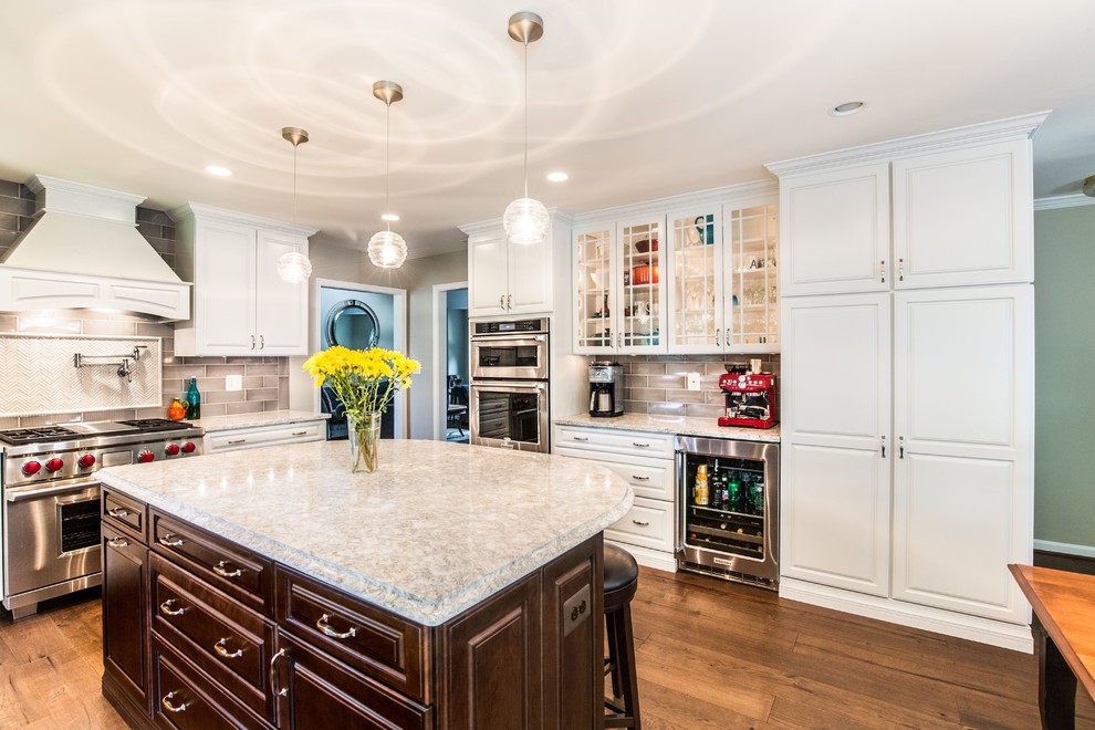 Design ideas for a large transitional u-shaped open plan kitchen in DC Metro with a single-bowl sink, beaded inset cabinets, white cabinets, quartz benchtops, grey splashback, ceramic splashback, stainless steel appliances, dark hardwood floors, with island and brown floor.