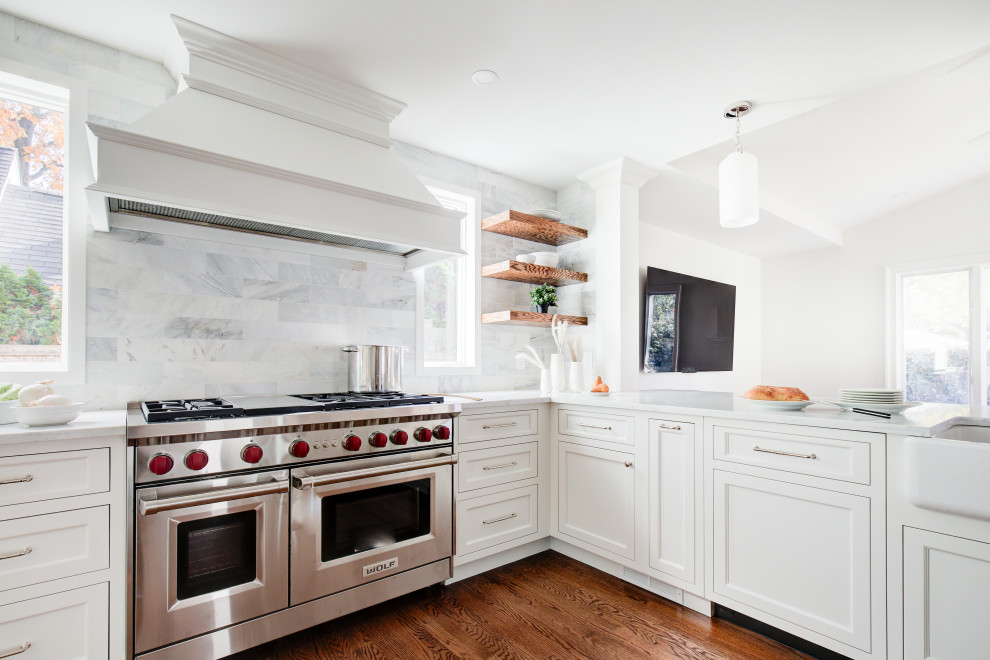 Mid-sized transitional u-shaped medium tone wood floor and brown floor open concept kitchen photo with a farmhouse sink, recessed-panel cabinets, white cabinets, quartz countertops, multicolored backsplash, marble backsplash, stainless steel appliances, a peninsula and white countertops