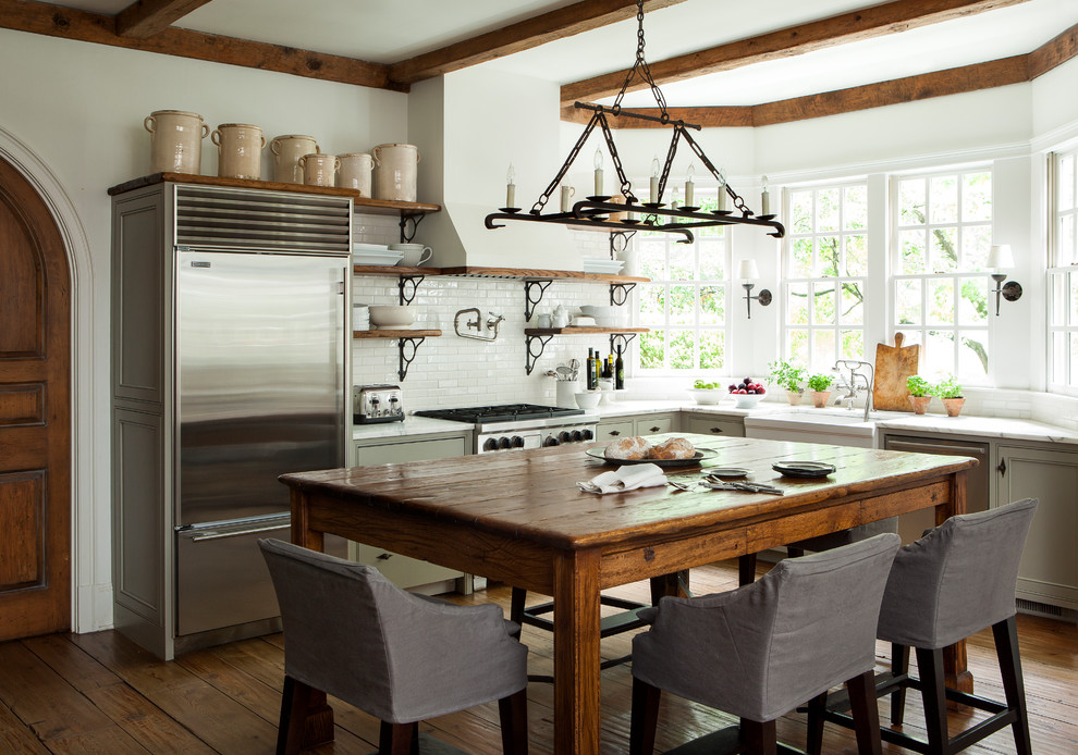 Inspiration for a country l-shaped kitchen in Atlanta with green cabinets, a farmhouse sink, beaded inset cabinets, white splashback, stainless steel appliances, dark hardwood floors, with island and brown floor.