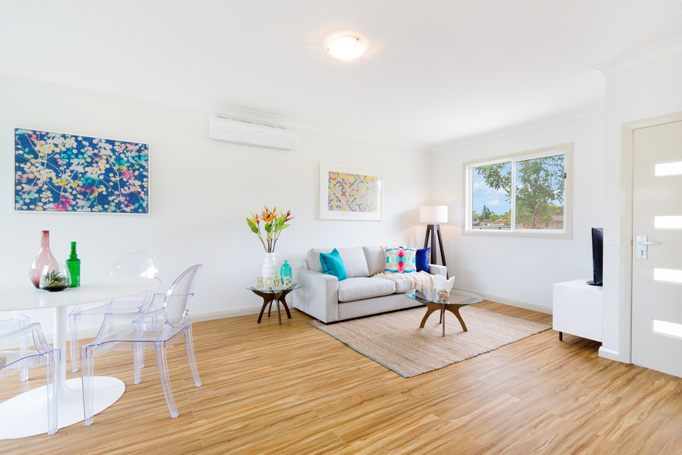 This is an example of a mid-sized contemporary living room in Sydney with beige walls and laminate floors.