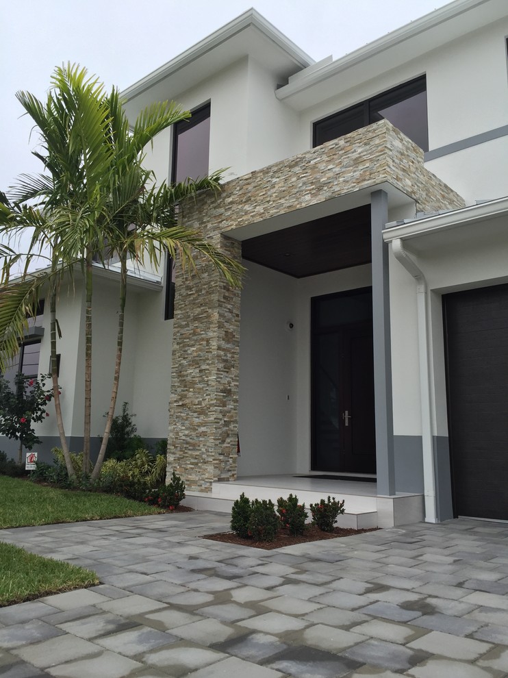 Photo of a mid-sized contemporary two-storey stucco white exterior in Miami.