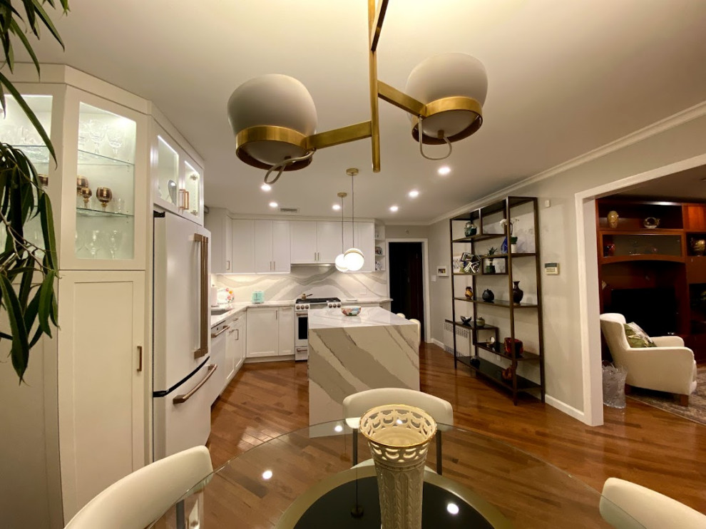 Exempel på ett mellanstort klassiskt vit vitt kök, med en undermonterad diskho, skåp i shakerstil, vita skåp, bänkskiva i kvarts, vitt stänkskydd, vita vitvaror, mörkt trägolv, en köksö och brunt golv