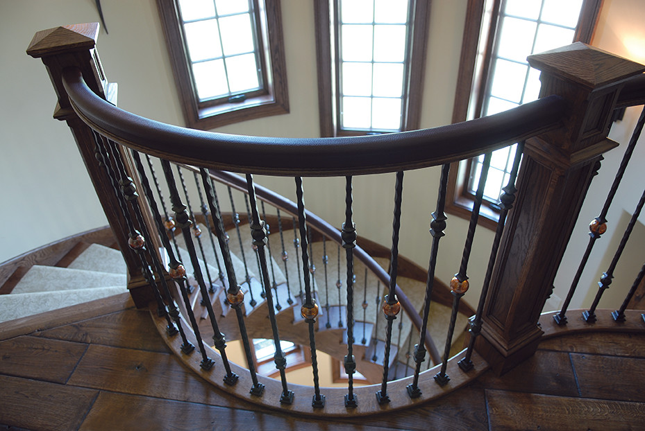 This is an example of a large victorian wood curved mixed railing staircase in Chicago with wood risers.