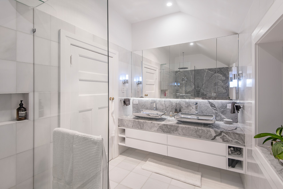 Design ideas for a mid-sized contemporary master bathroom in Brisbane with flat-panel cabinets, an alcove shower, ceramic tile, white walls, a vessel sink, marble benchtops, white floor, an open shower, grey benchtops, white cabinets and gray tile.