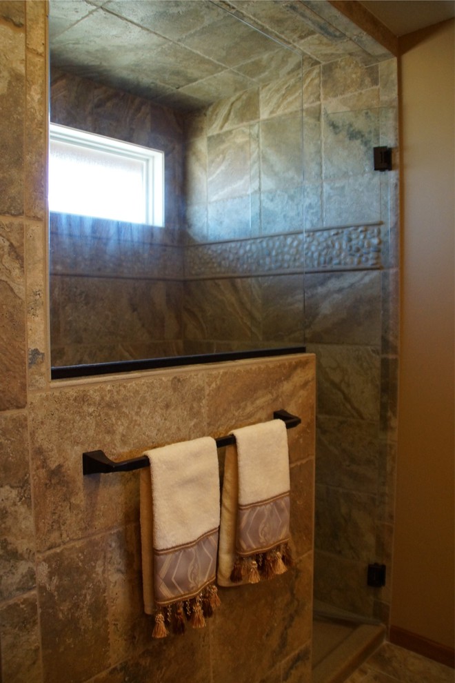 Inspiration for a mid-sized rustic master multicolored tile and stone tile travertine floor alcove shower remodel with raised-panel cabinets, medium tone wood cabinets, a one-piece toilet, beige walls, an undermount sink and granite countertops