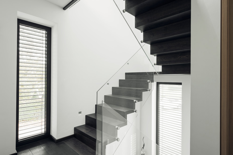 Exemple d'un escalier moderne en U de taille moyenne avec des marches en bois, des contremarches en bois et un garde-corps en verre.