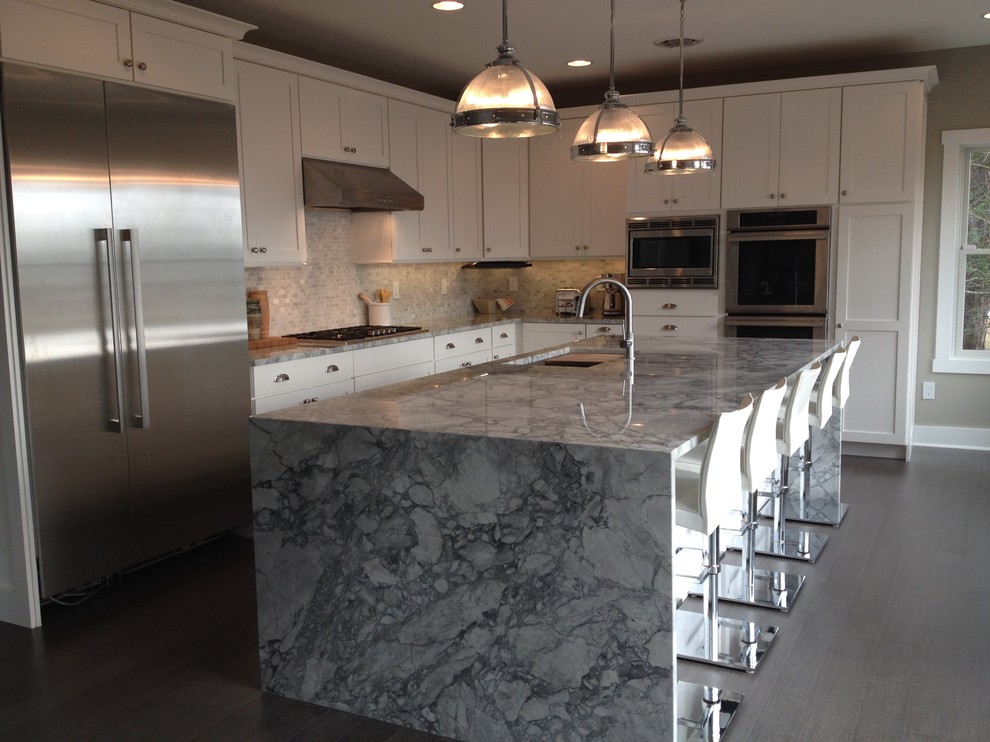 Mid-sized transitional l-shaped medium tone wood floor and gray floor eat-in kitchen photo with an undermount sink, shaker cabinets, white cabinets, marble countertops, gray backsplash, mosaic tile backsplash, stainless steel appliances and an island