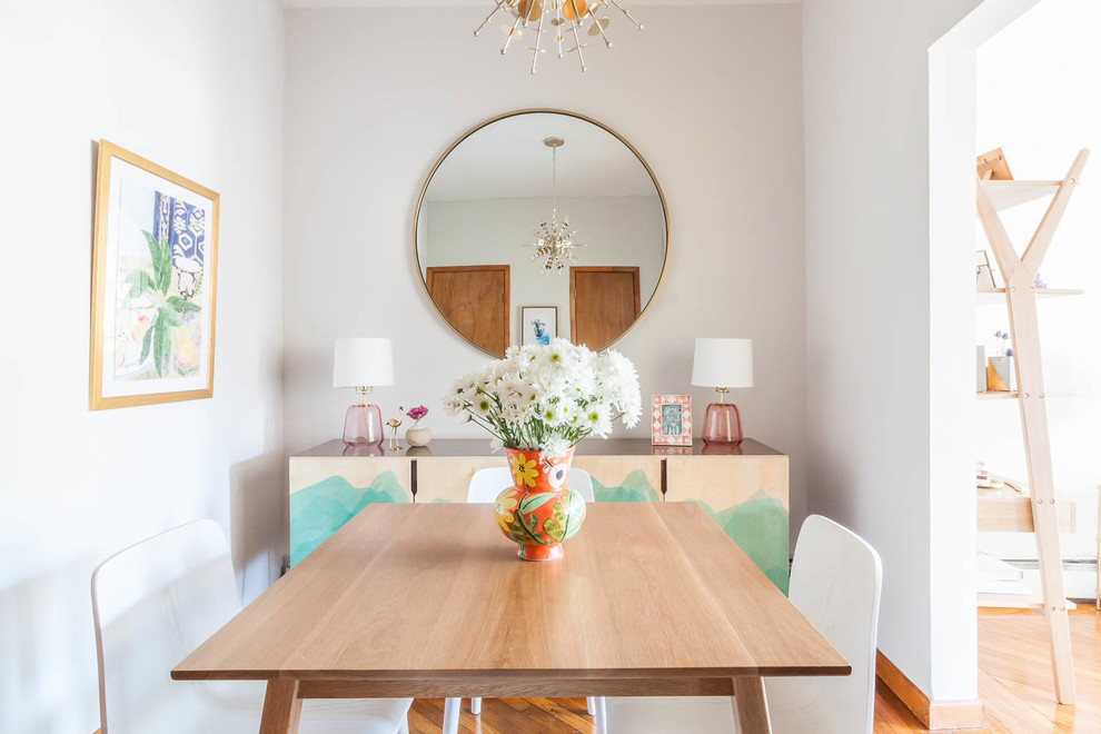 Inspiration for a small eclectic separate dining room in New York with grey walls, medium hardwood floors and brown floor.