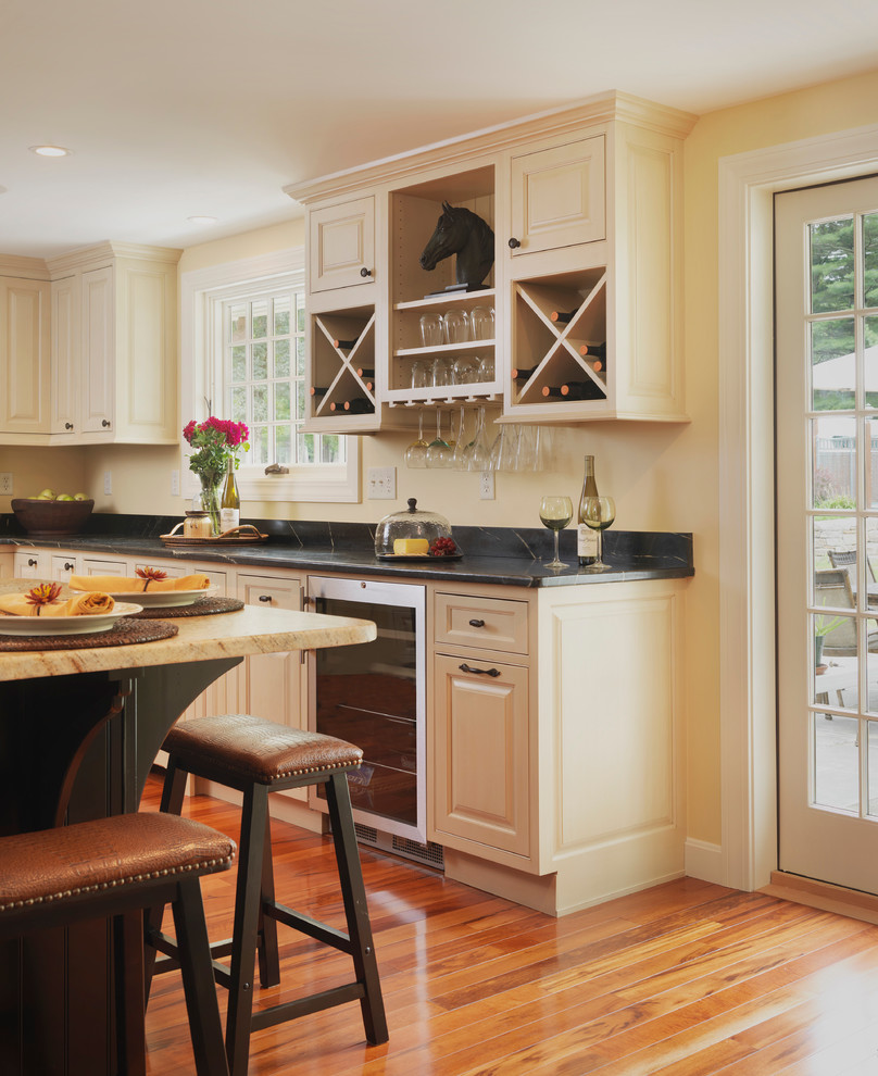 This is an example of a mid-sized transitional l-shaped eat-in kitchen in Providence with beaded inset cabinets, white cabinets, stainless steel appliances, medium hardwood floors and with island.