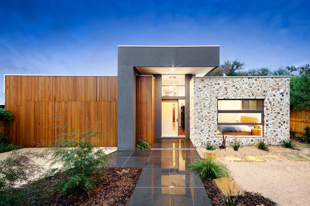 This is an example of an expansive contemporary one-storey exterior in Melbourne with mixed siding and a flat roof.
