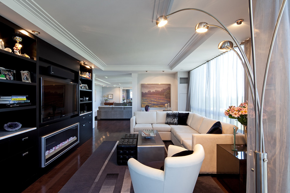 Photo of a contemporary open concept family room in Toronto with white walls, dark hardwood floors and a built-in media wall.