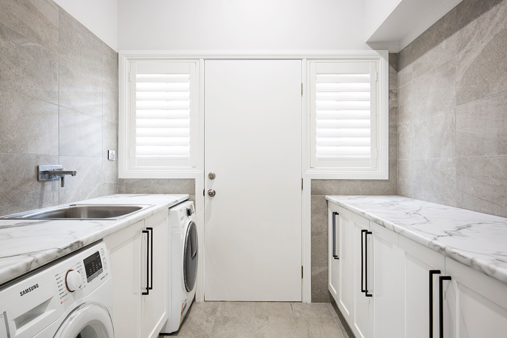 Inspiration for a large transitional galley dedicated laundry room in Sydney with a single-bowl sink, shaker cabinets, white cabinets, laminate benchtops, multi-coloured walls, porcelain floors, a side-by-side washer and dryer, multi-coloured floor and multi-coloured benchtop.