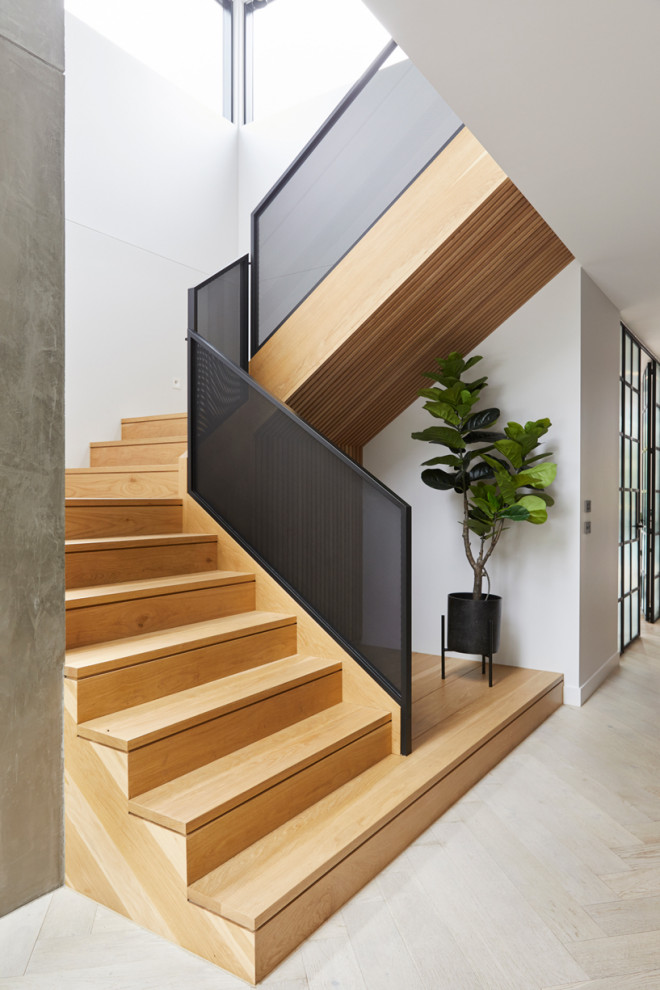 Свежая идея для дизайна: большая п-образная деревянная лестница в современном стиле с деревянными ступенями и металлическими перилами - отличное фото интерьера
