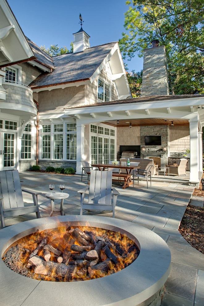 Inspiration for a traditional sloped garden in Minneapolis with a fire feature and natural stone pavers.