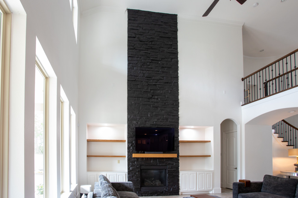 Foto de salón abierto moderno grande con paredes negras, todas las chimeneas, marco de chimenea de ladrillo y televisor independiente