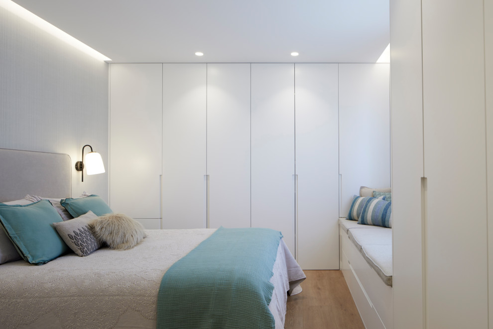 Источник вдохновения для домашнего уюта: спальня в белых тонах с отделкой деревом в современном стиле с полом из ламината