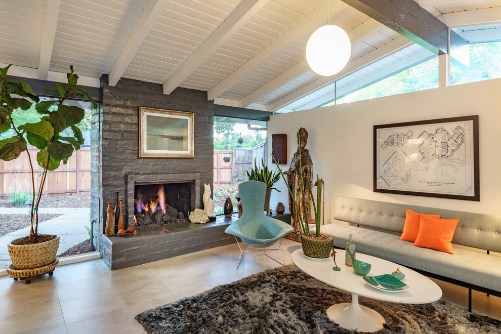 Mid-century modern open concept living room photo in Other with white walls, a standard fireplace and a brick fireplace