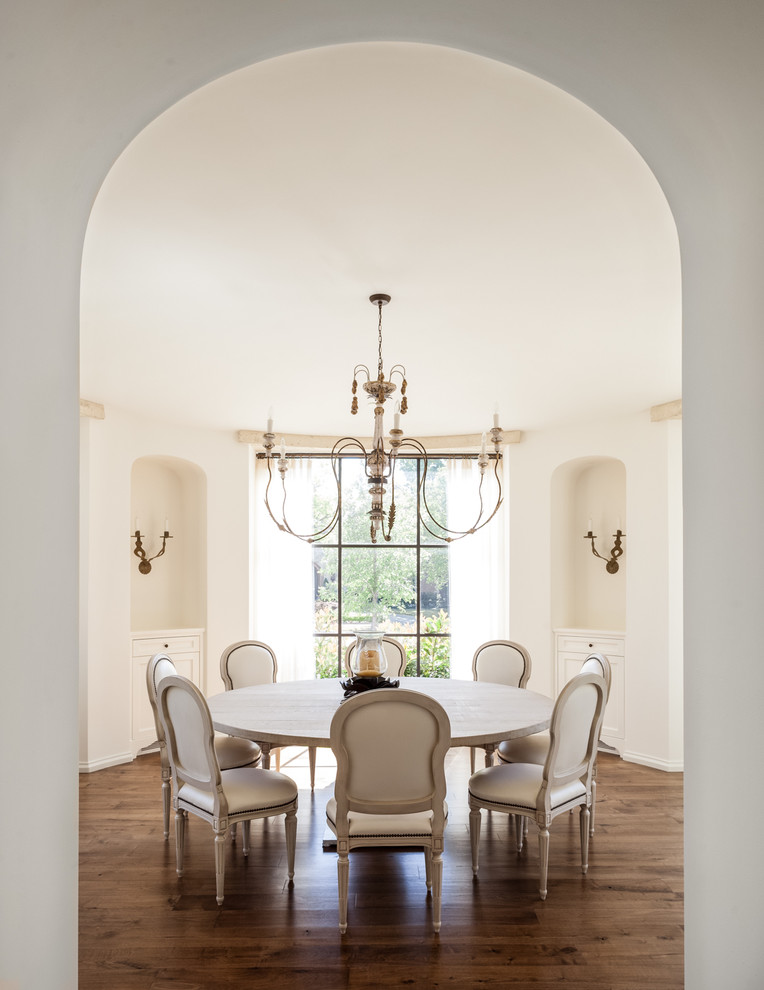 Mediterranean separate dining room in Dallas with white walls, medium hardwood floors and no fireplace.