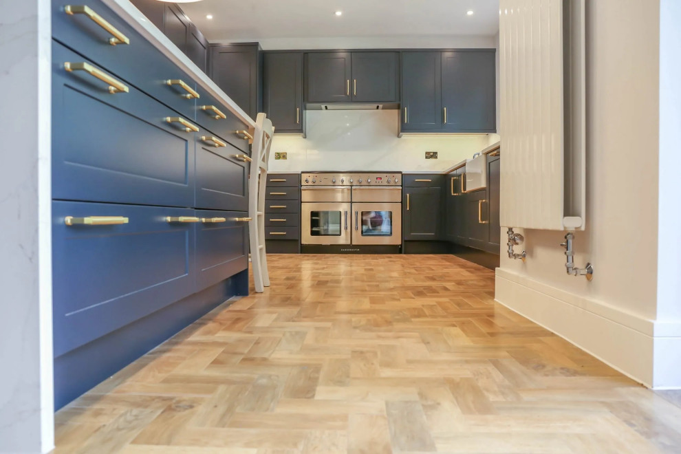 ロンドンにある低価格の広いコンテンポラリースタイルのおしゃれなキッチン (インセット扉のキャビネット、青いキャビネット、ドロップインシンク、銅製カウンター、青いキッチンパネル、木材のキッチンパネル、シルバーの調理設備、セラミックタイルの床、茶色い床、茶色いキッチンカウンター、板張り天井) の写真