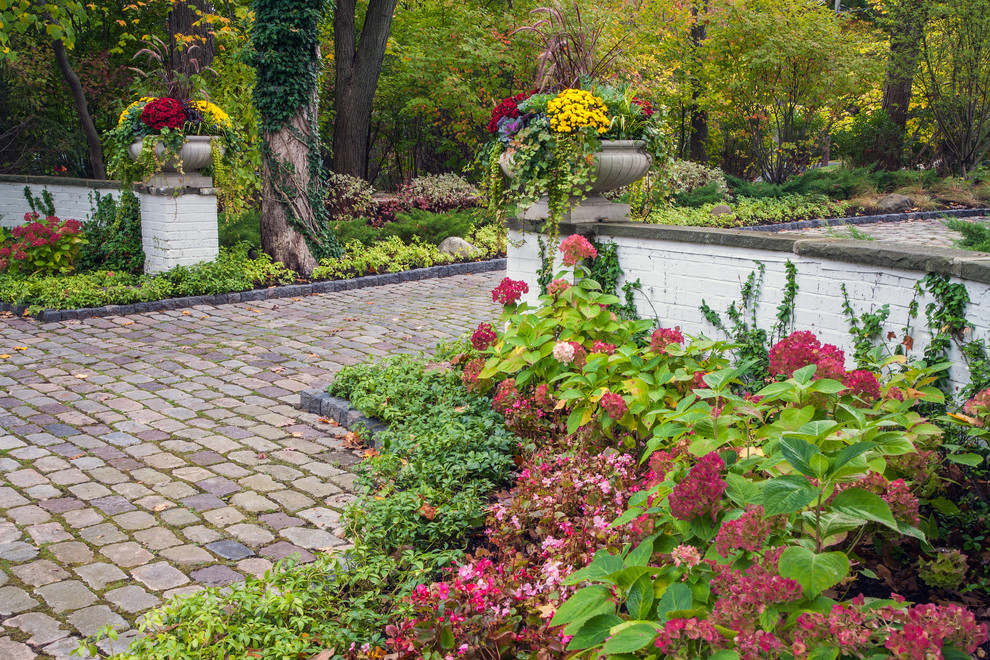 Klassischer Garten mit Auffahrt, Natursteinplatten und Blumenbeet in Chicago