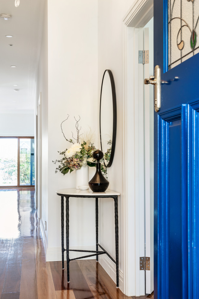 Photo of a small transitional foyer in Melbourne with white walls, dark hardwood floors, a single front door, a blue front door, brown floor, recessed and panelled walls.