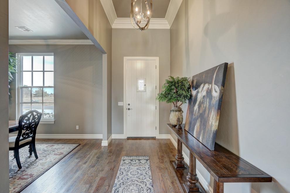 Photo of a mid-sized transitional front door in Oklahoma City with grey walls, light hardwood floors, a single front door, a white front door and brown floor.