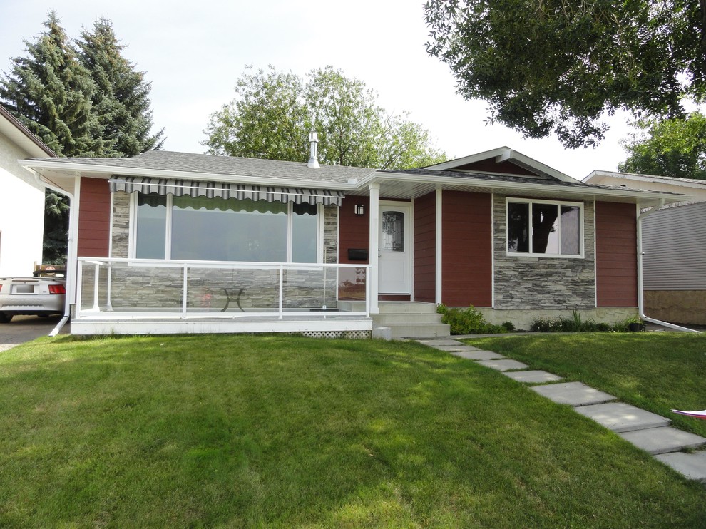 This is an example of a mid-sized traditional one-storey red exterior in Calgary with concrete fiberboard siding.