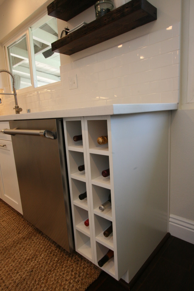 Eat-in kitchen - large transitional u-shaped dark wood floor eat-in kitchen idea in Orange County with a farmhouse sink, shaker cabinets, white cabinets, quartz countertops, white backsplash, ceramic backsplash, stainless steel appliances and an island