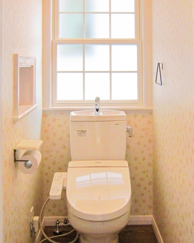 Design ideas for a mid-sized country powder room in Other with a one-piece toilet, white tile, white walls, dark hardwood floors, an integrated sink and brown floor.