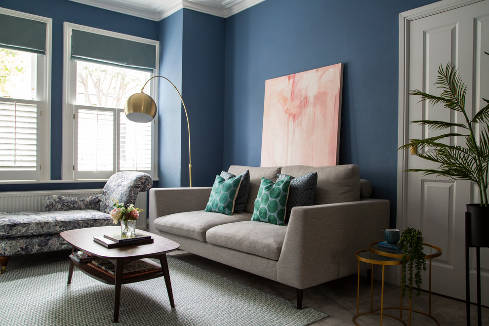 This is an example of a mid-sized modern formal enclosed living room in London with blue walls, carpet, a freestanding tv and grey floor.