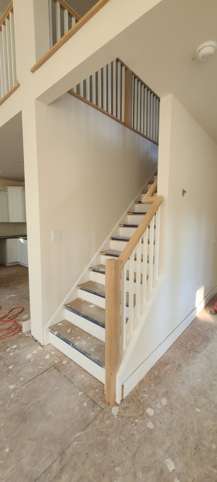 This is an example of a medium sized classic wood straight wood railing staircase in New York with wood risers.