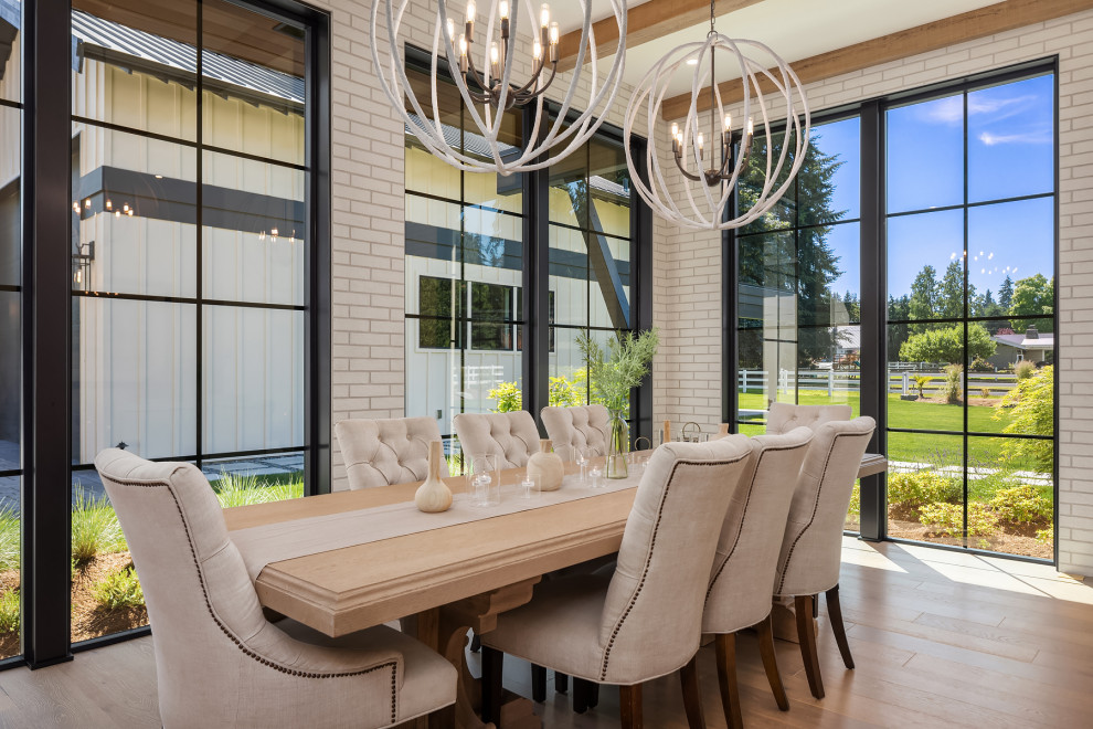 This is an example of a transitional dining room in Seattle with brick walls.