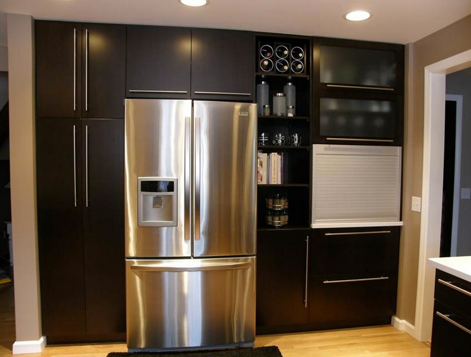 Enclosed kitchen - mid-sized modern u-shaped light wood floor enclosed kitchen idea with an undermount sink, flat-panel cabinets, dark wood cabinets, quartz countertops, brown backsplash, ceramic backsplash, stainless steel appliances and a peninsula