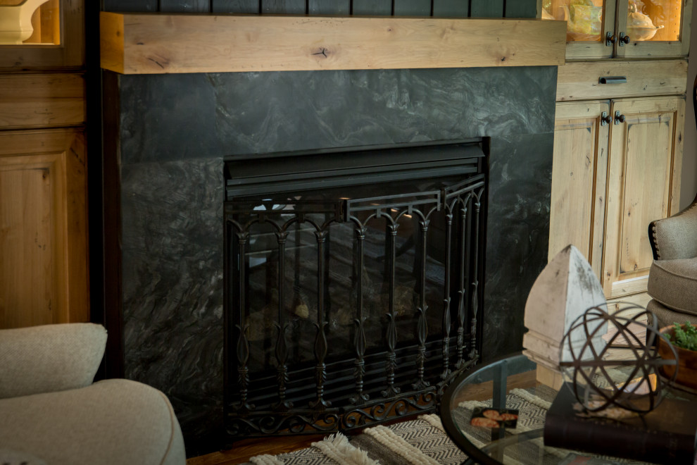 Eat-in kitchen - large rustic open concept and l-shaped light wood floor and brown floor eat-in kitchen idea with white walls, a wood stove, a stone fireplace, an undermount sink, recessed-panel cabinets, dark wood cabinets, quartz countertops, white backsplash, quartz backsplash, stainless steel appliances, an island and white countertops