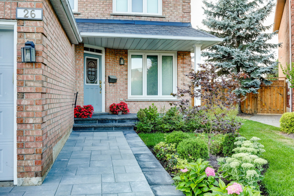 This is an example of a small transitional front yard pool in Toronto with natural stone pavers.